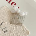 Détail macro d'un peigne à nœud en acétate blanc avec sept dents en métal argenté pour coiffure - Blanc Perle