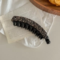 Detailed view of tortoise shell pattern banana hair clip with double teeth on vintage paper - Dark Brown Floral