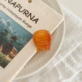 Detailed close-up of a mini amber acetate hair claw with gold France Handmade logo - Caramel Pattern