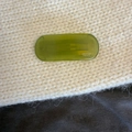 Close-up of a translucent green acetate hair clip featuring Creation France text on a knit background - Green