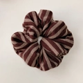 Detail der weichen Strickstruktur und des braun gestreiften Musters auf dem Scrunchie - Braun