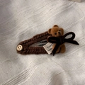 Detail of knitted hair clip with brown flocked bear, velvet bow and wooden button decoration - Brown