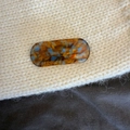 Close-up of oval amber and blue tortoise hair clip with Creation France logo text - Blue Brown Gradient