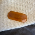 Detail view of amber tortoiseshell acetate hair clip with Creation France logo text - Caramel color