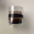 Gros plan d'élastiques tressés aux tons terre dans un pot cylindrique clair - Brun Café Foncé (G)