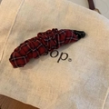 Détail du tissu à carreaux rouge et noir plissé sur une pince banane rétro chic - Plaid Rouge