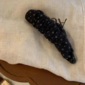 Détail d'une pince banane en tissu noir avec de petits motifs floraux blancs élégants - Pois Noirs
