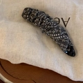 Détail de la pince banane à fleurs blanches sur un tissu écossais gris élégant - Pois Gris