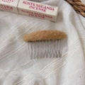 Detailed macro view of an oval plush hair comb with brown faux fur and silver metal teeth - Orange
