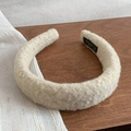 Detail showing plush cream lamb wool texture and brand label on a soft winter headband - Off White