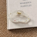 Detail of cream resin hair claw with colorful rhinestones and gold spring on a book - Cloud Hair Claw