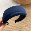 Dettaglio ravvicinato del cerchietto imbottito blu scuro con trama in tessuto di lana fine - Blu