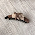 Detail van de bananenklem met pluche beer en bruine geruite stof op witte ondergrond - Donkere Koffie Ruitjes