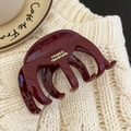 Dettaglio di una pinza per capelli rosso vino lucido con incisione dorata su maglia - Forma di Zucca Rossa