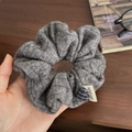 Détail d'un chouchou en tricot gris avec maille torsadée et breloque coeur bleu - Chouchou Gris