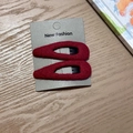 Set of two red fabric teardrop hair clips on display card with a premium wood background - Red