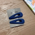 Detail view of two dark blue fabric-wrapped teardrop hair clips with soft knit texture - Blue