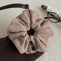 Gros plan sur un chouchou en tricot marron clair avec texture fine et étiquette de logo - Couleur Thé au Lait