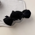 Detaillierte Nahaufnahme einer schwarzen Strickschleife-Haarklammer mit Bändern - Schwarz