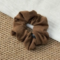 Détail de la texture en tricot marron et de l'étiquette tissée noire d'un chouchou - Marron
