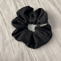 Detail shot of a dark grey knit scrunchie with a handmade tag on beige fabric background - Dark Gray