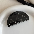 Close-up of black quilted hair claw clip with rhinestones on a white ceramic plate - Black Semi-Circle Claw Clip