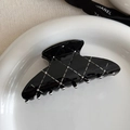 Detail of elegant black quilted hair claw clip with rhinestones on ceramic tray - Black Arc Shaped Claw Clip