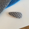 Nahaufnahme einer grauen gestrickten Haarspange mit weißen Punkten auf weißem Hintergrund - Tropfenform (5995598465858) / Graues Dreieck