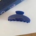 Close-up of dark blue acetate hair claw clip with white polka dots on denim background - Blue Polka Dot
