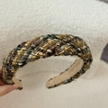Detailaufnahme eines Retro-Haarreifens aus Tweed mit mehrfarbiger gewebter Textur - Gelbgrüner Tweed