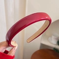 Close-up of a glossy red headband with non-slip velvet lining and premium texture - Leather