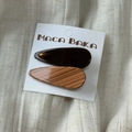 Detail of tortoiseshell patterned acetate hair clips in brown and orange on linen - Teardrop Style Pair