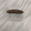 Dettaglio di un pettine per capelli in tweed a spina di pesce marrone con dieci denti in metallo - Marrone