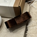Detail shot of the dark brown double-sided velvet bow banana clip on a textured surface - Dark Brown