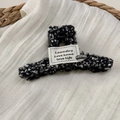 Close-up of black and white tweed hair claw clip with Laundry Love fabric label and metal badge - Hair Claw / Black