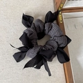 Elegant black woven bow scrunchie for women with layered chiffon ribbons on beige fabric - Black
