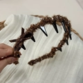 Close-up of brown bouclé headband featuring a plaid bow and inner plastic teeth - Headband / Coffee