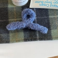 Dettaglio della molletta per capelli in peluche blu Morandi su tessuto a quadri verdi - Blu