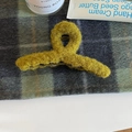 Detail der flauschigen senfgelben Haarklammer mit weicher Teddy-Fleece-Textur - Gelbgrün