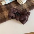 Detailansicht der dunkelbraunen Strick-Schleifen-Haarklammer mit eleganter Stofftextur - Braun