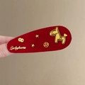Nahaufnahme einer roten beflockten Haarspange mit goldenem Pferd und Münzdetails - Rot