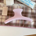 Pince à cheveux rose mat élégante pour femme sur fond de tissu à carreaux douillet - Arc