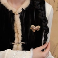 Detailed close-up of a handcrafted Songjin silk pony brooch on a black velvet vest - Brown