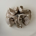 Detail view of champagne satin hair scrunchie with beaded edges and elegant folds - Khaki