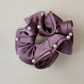 Detailed view of purple satin scrunchie with elegant white pearls and ruffled edges - Purple