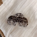 Detail of tortoise shell hair claw clip with golden La France logo on linen fabric - Gray Leopard Curved