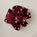 Detailed close-up of wine red satin scrunchie with elegant faux pearl bead embellishments - Red