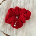 Festive red plush scrunchie made of soft faux fur placed in a white woven basket - Red Plush Scrunchie