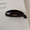 Macro detail of dark brown resin banana hair clip with elegant golden calligraphy lettering - Large Size Brown