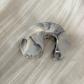 Macro shot of marble textured hair claw clip with glossy finish on beige fabric - Creamy White Arc Style (Style B)